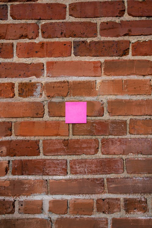 Sticker Note on Rough Red Brick Wall