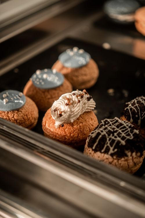 Free A selection of baked pastries with icing and cream on display in a bakery. Stock Photo