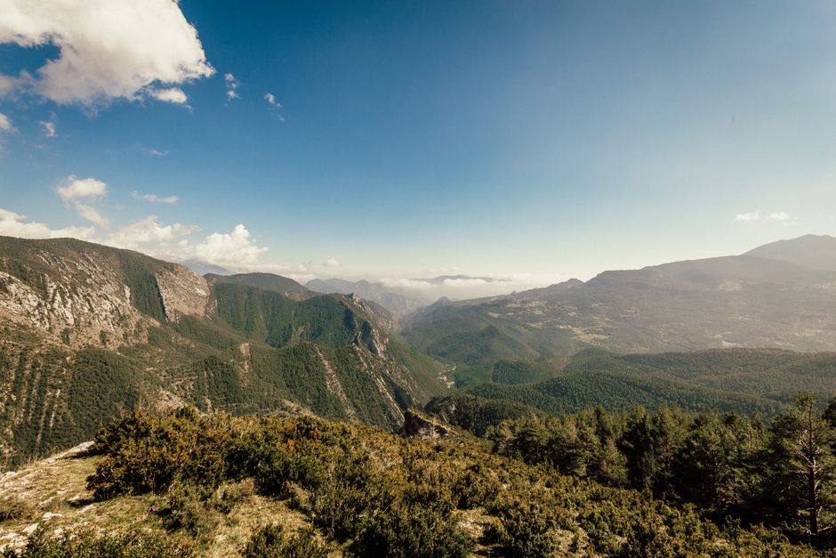 Breathtaking view of mountain ridges and valleys under a bright blue sky. Perfect for nature lovers.