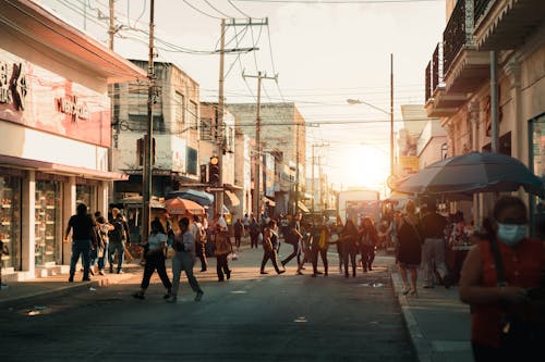 People Walking on City Street on Sunset