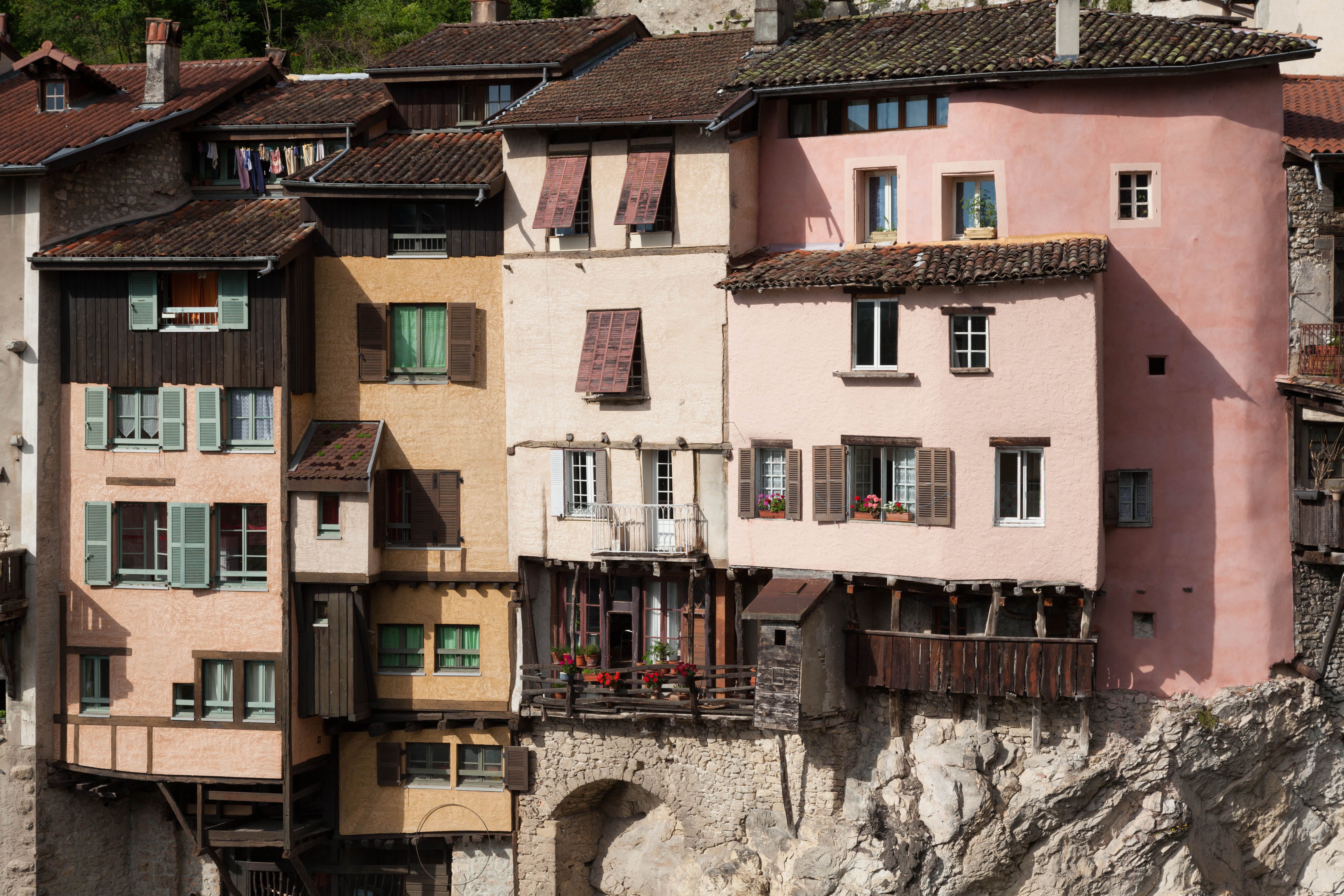 Colorful, traditional hillside houses in Pont-en-Royans, France, showcasing unique architecture.