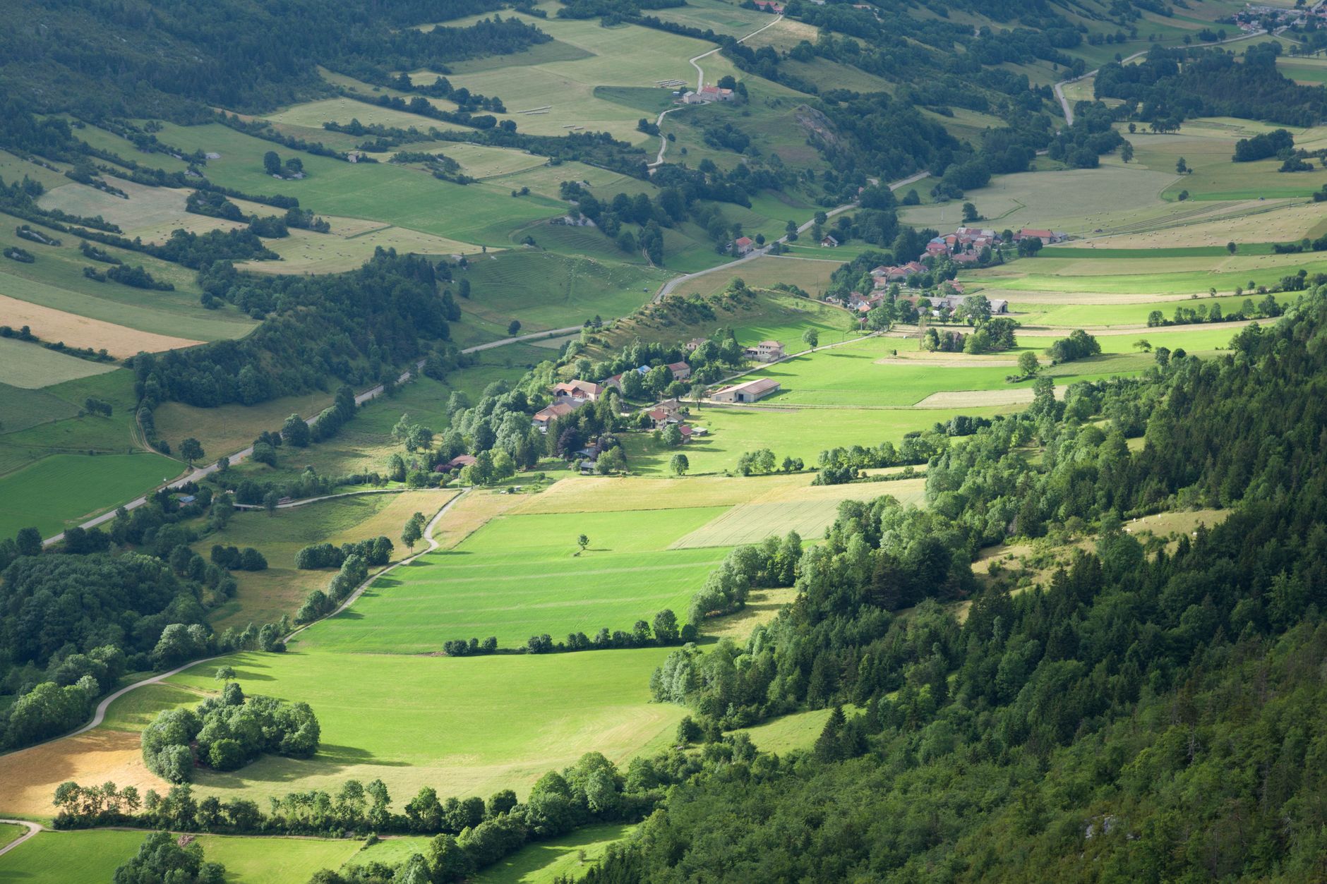 Stunning aerial photograph of lush green fields and villages in Vercors, France.