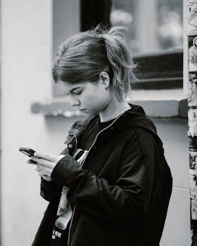 Black and white portrait of a young woman using her phone on a street in Istanbul.
