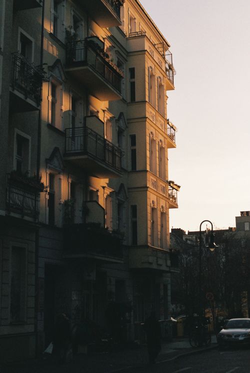 Free Urban residential building facade illuminated by the soft glow of dusk in a city setting. Stock Photo