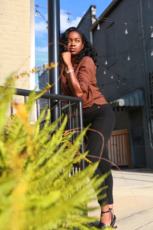 Woman in Brown Shirt Leaning on Bar