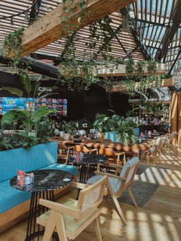 Stylish café interior with greenery, glass roof, and wooden accents in Istanbul.