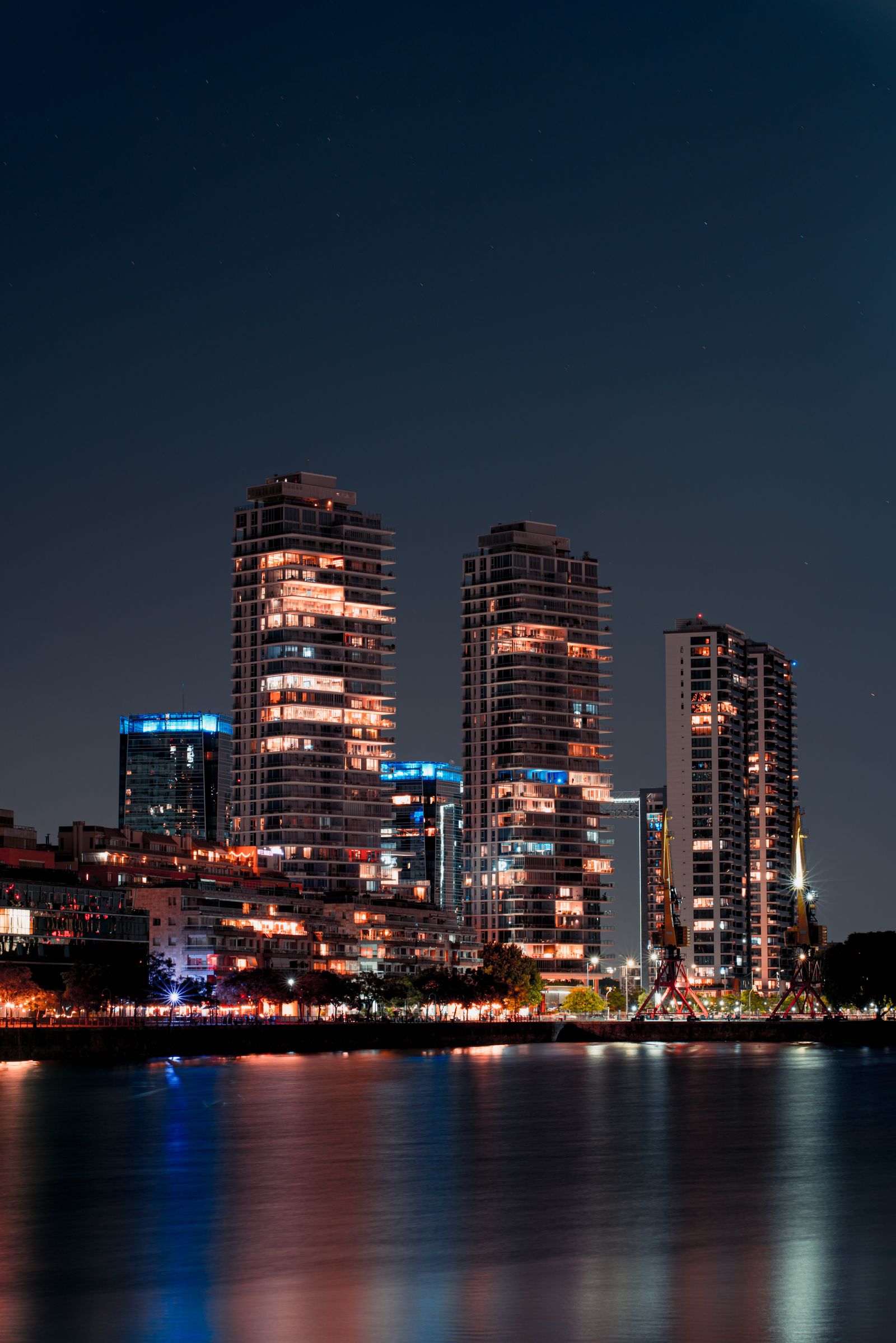 Métropole au bord de l'eau, de nuit Ville illuminée au bord de la rivière, vue nocturne