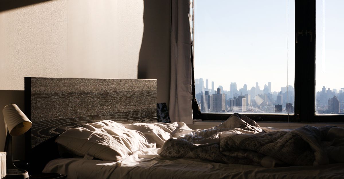 person meditating at sunrise in a city apartment window