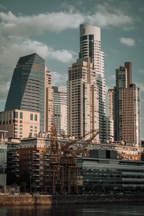 Free A stunning cityscape featuring modern skyscrapers and cranes against a cloudy sky. Stock Photo