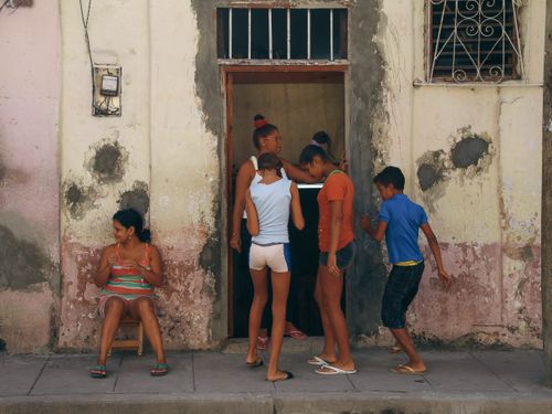 Free Children playing outside a vintage building in Havana, Cuba, showcasing local life. Stock Photo
