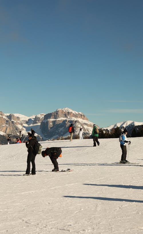 View of People Skiing in Mountains under a Clear, Blue Sky 