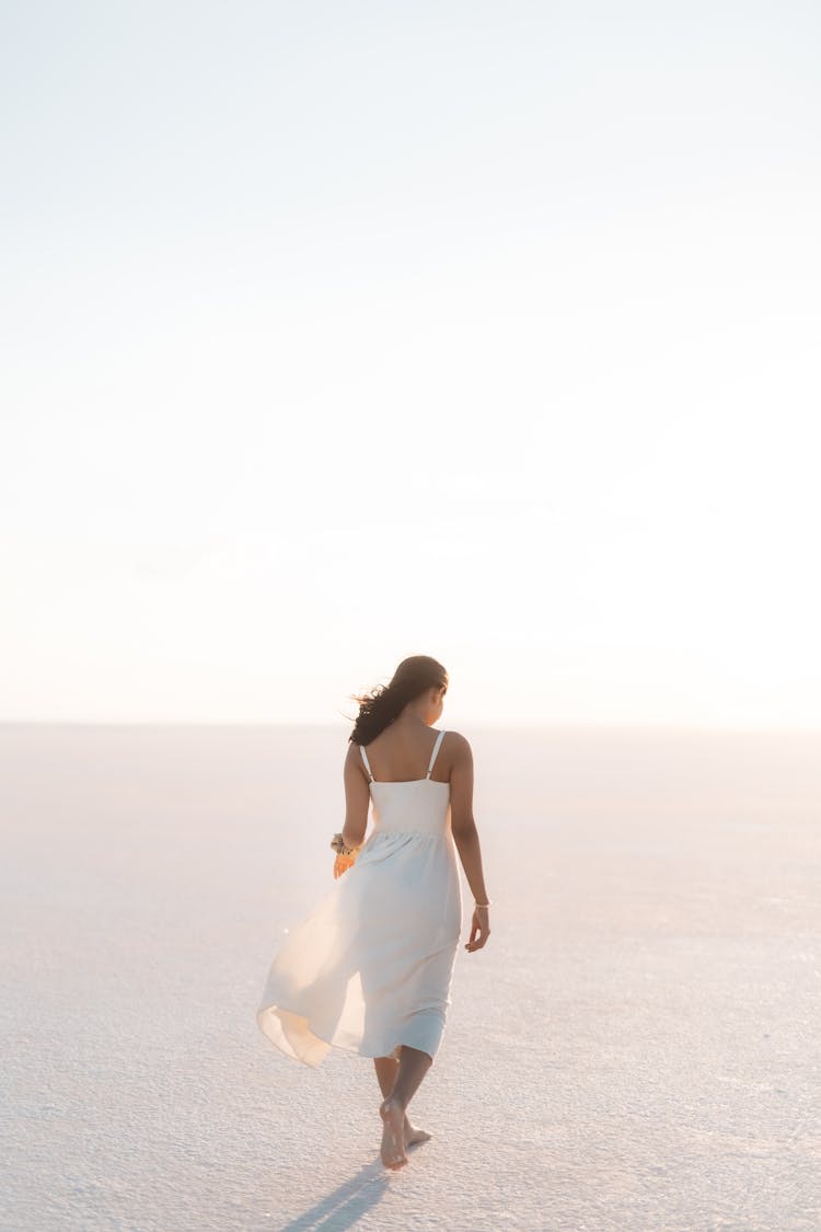 Woman In Dress Walking On Salt Lake