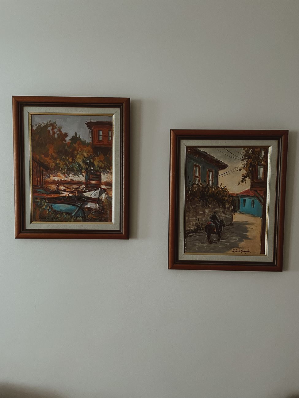 Two framed paintings on a white wall depicting Istanbul-inspired scenes.