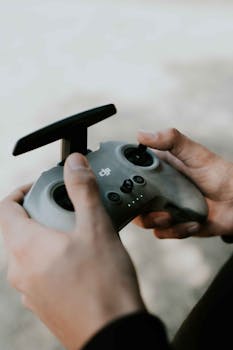 Hands holding a drone controller, focusing on the technology and user interaction.