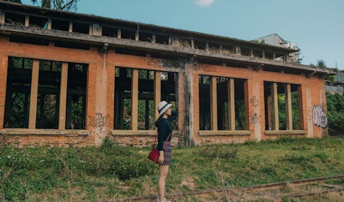 Woman Standing Near Brick Building