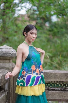 Young Asian woman in colorful traditional attire outdoors, showcasing vibrant fashion.