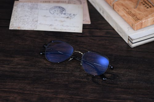 Black Framed Eyeglasses on Brown Wooden Surface