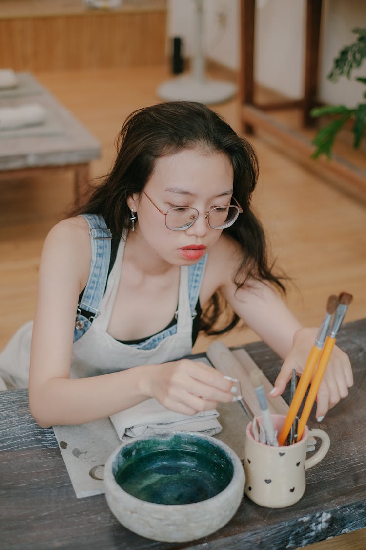 Woman Choosing Brush For Painting