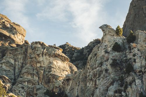 Free Dramatic rocky cliffs with sparse vegetation under a clear sky, showcasing natural geological formations. Stock Photo