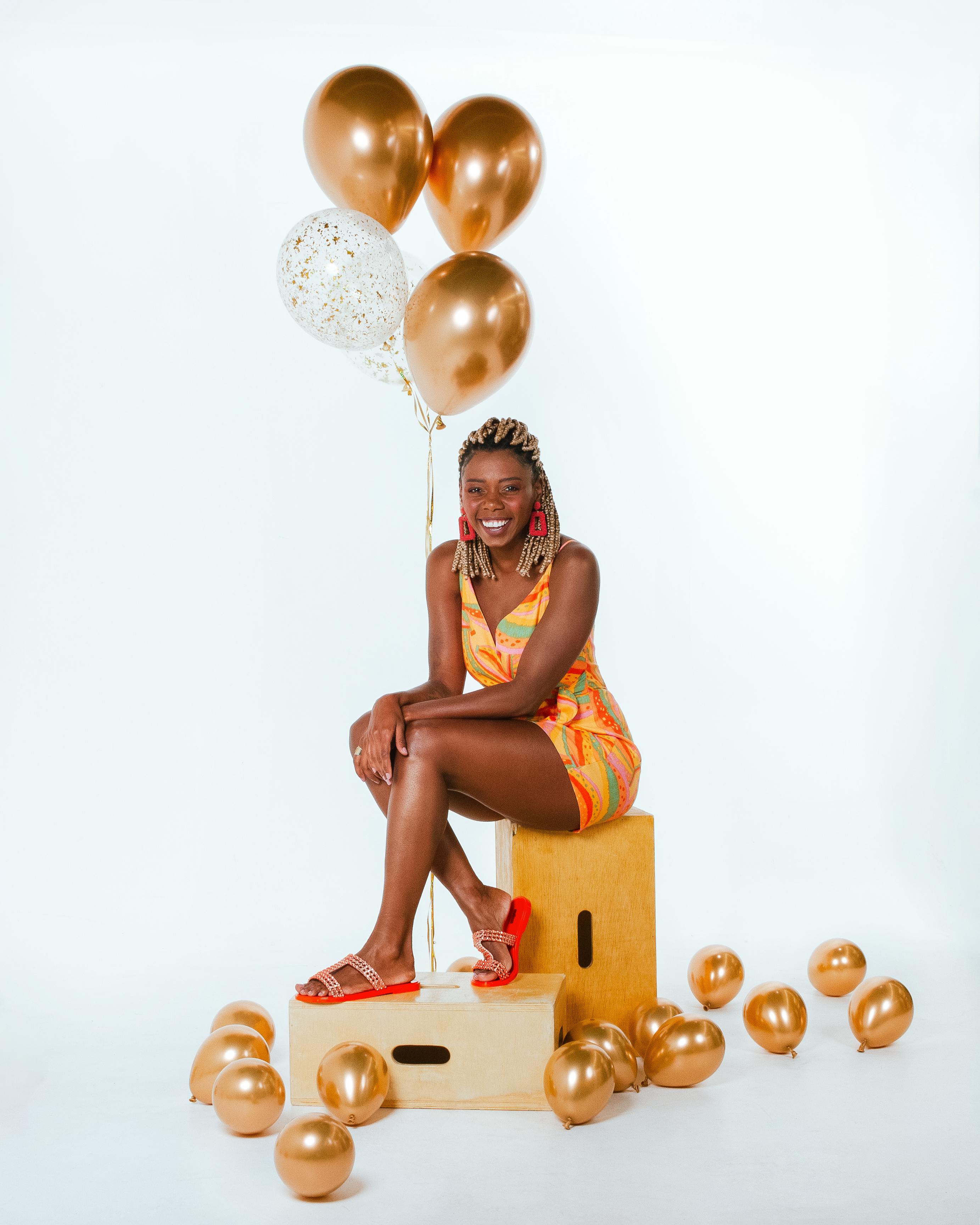 grátis Mulher Sorridente Sentada Com Balões Foto profissional