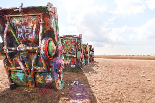 Colorful vintage cars covered in graffiti art at the famous Cadillac Ranch, Texas.