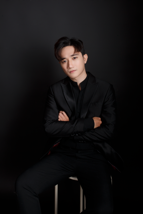 Free Elegant portrait of a man in a black suit sitting against a dark background. Stock Photo
