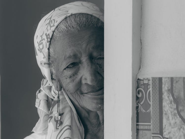 Black And White Headshot Of A Senior Woman Peeking Out