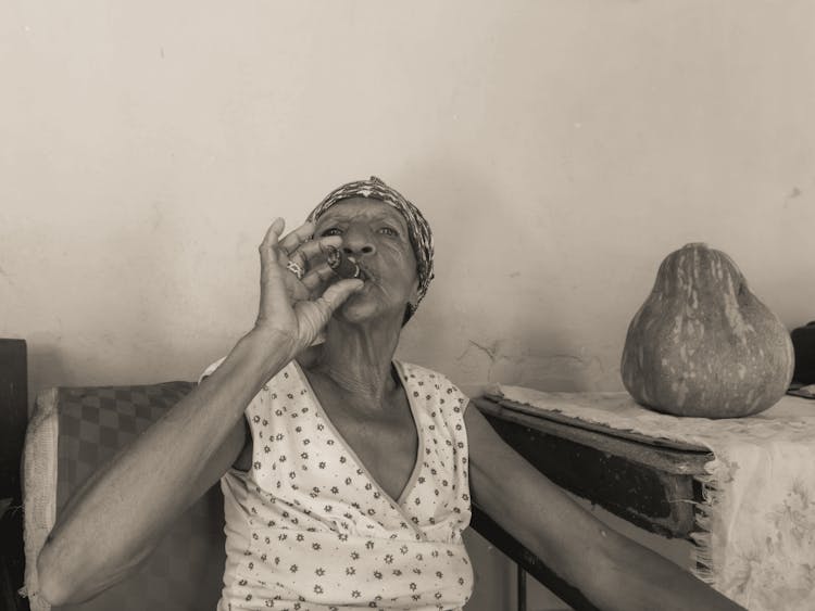 An Elderly Woman Smoking A Cigar 