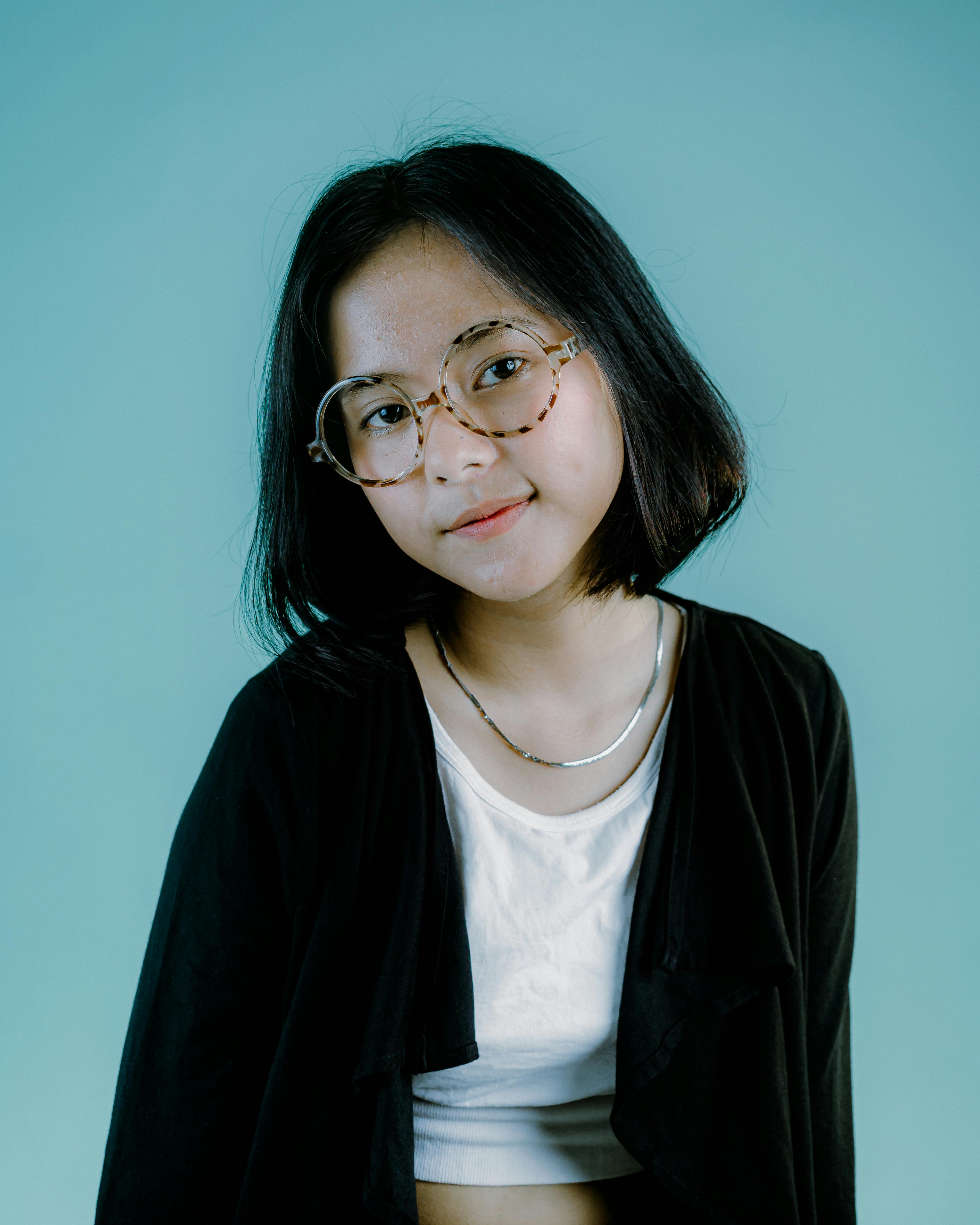 a girl in black coat wearing eyeglasses