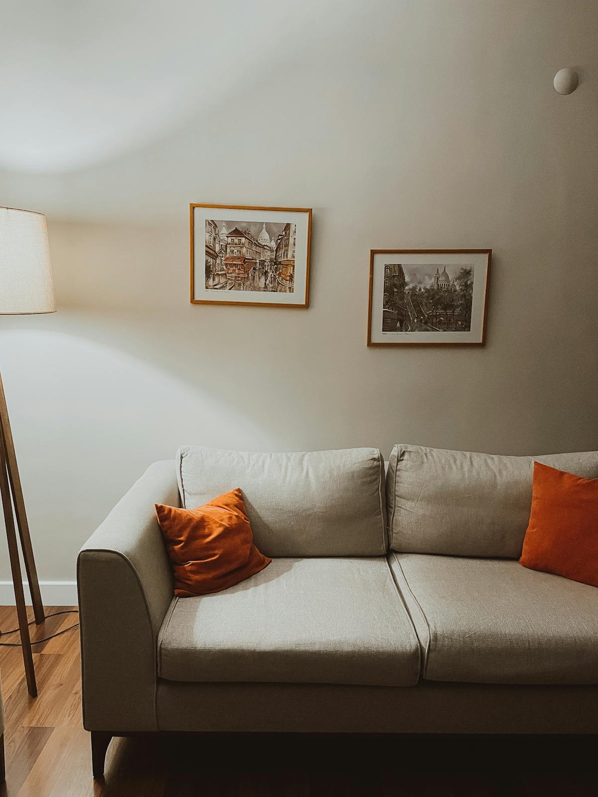 Divano bianco moderno con cuscini arancioni in soggiorno luminoso