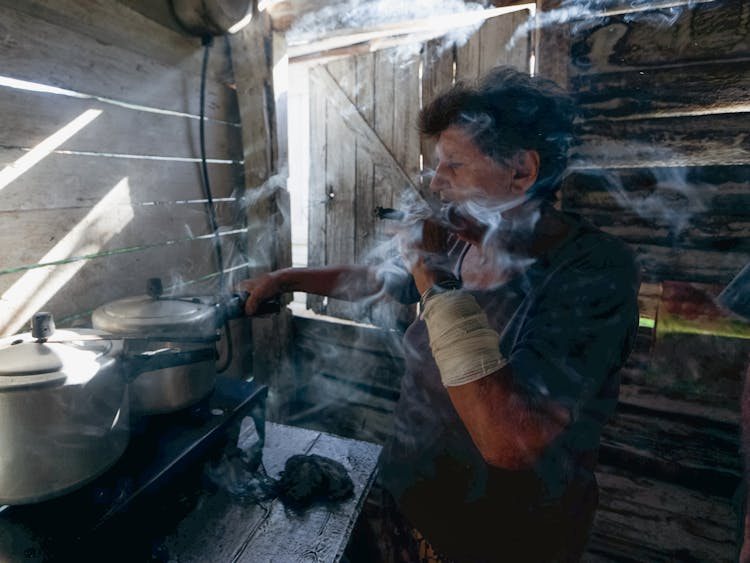 Woman Cooking In A Wooden Kitchen