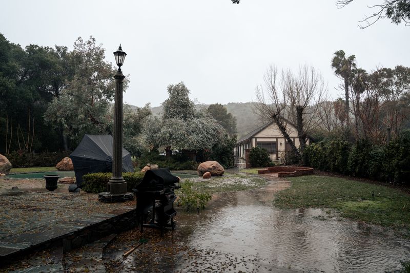 Standing water in a suburban yard after heavy rain — a sign of poor drainage near the foundation