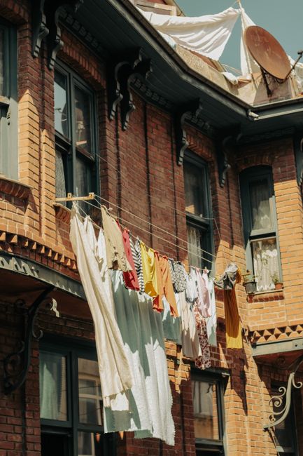Vibrant laundry hanging on a clothesline outside a vintage brick residential building.