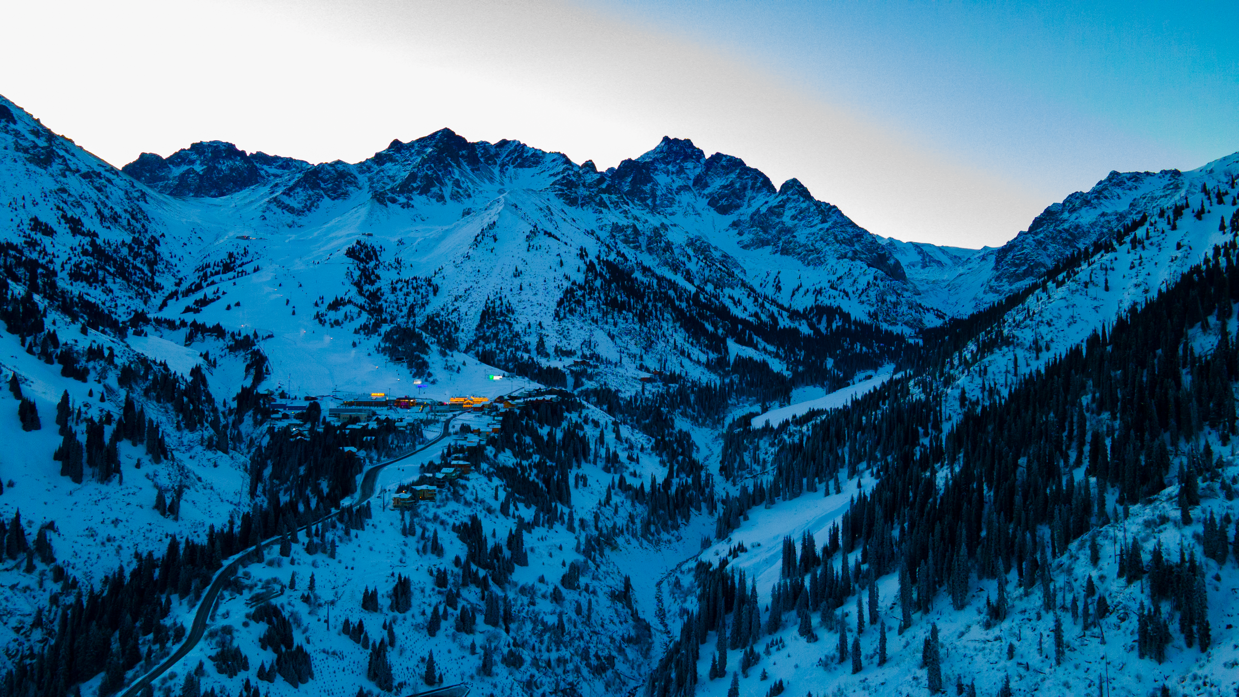 A stunning winter aerial view of Медеу mountains, capturing snow-covered peaks and valleys.