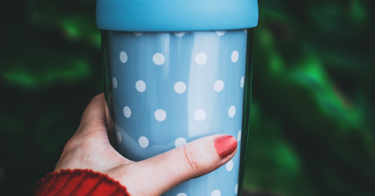 Person Holding Teal and White Polka-dot Tumbler