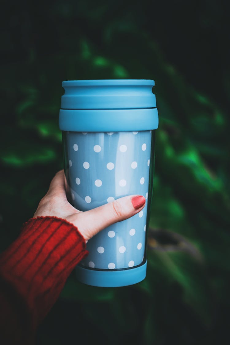 Person Holding Teal And White Polka-dot Tumbler