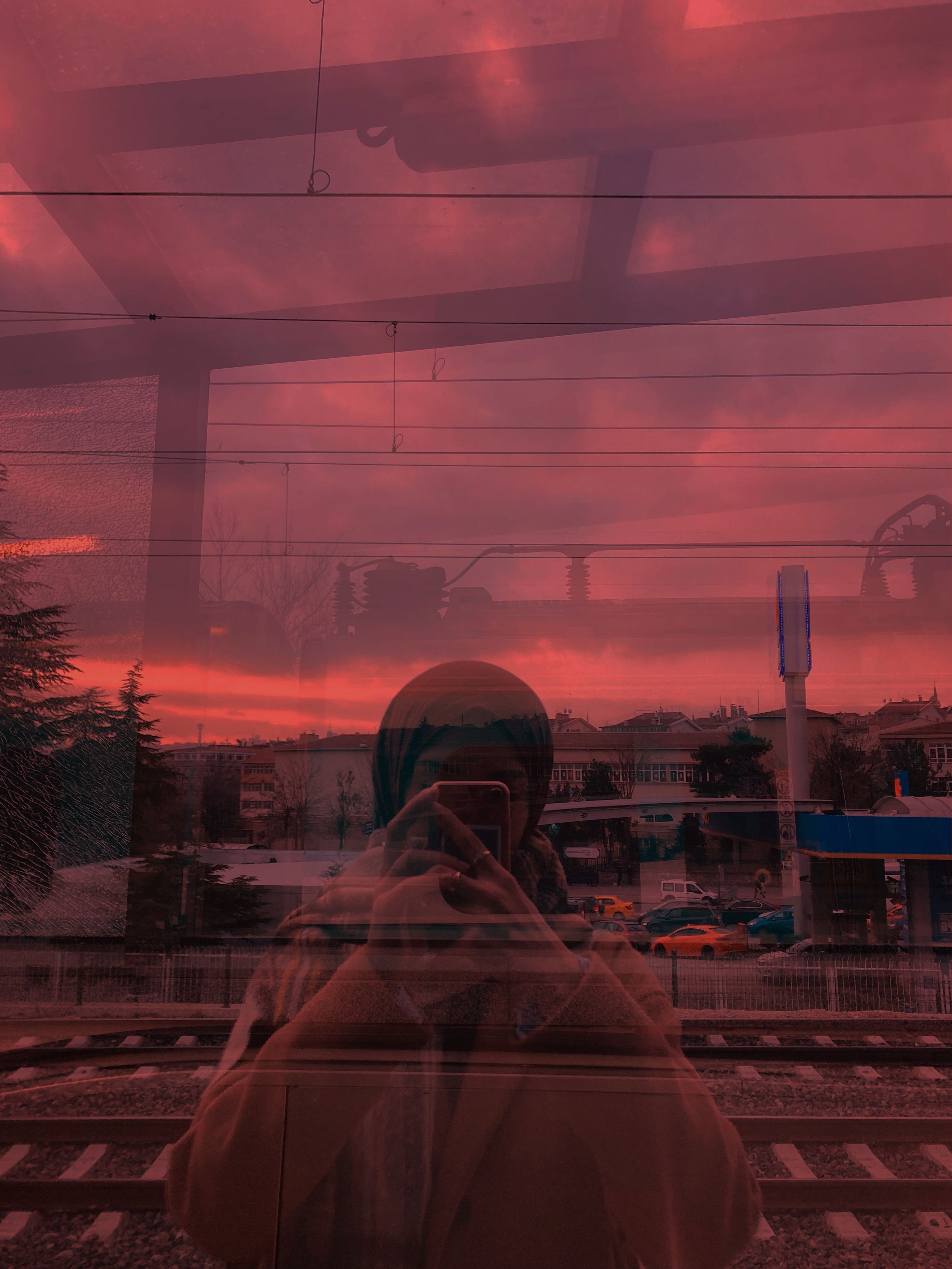 A captivating reflection of a woman in a hijab taking a selfie at sunset in Ankara, Türkiye.