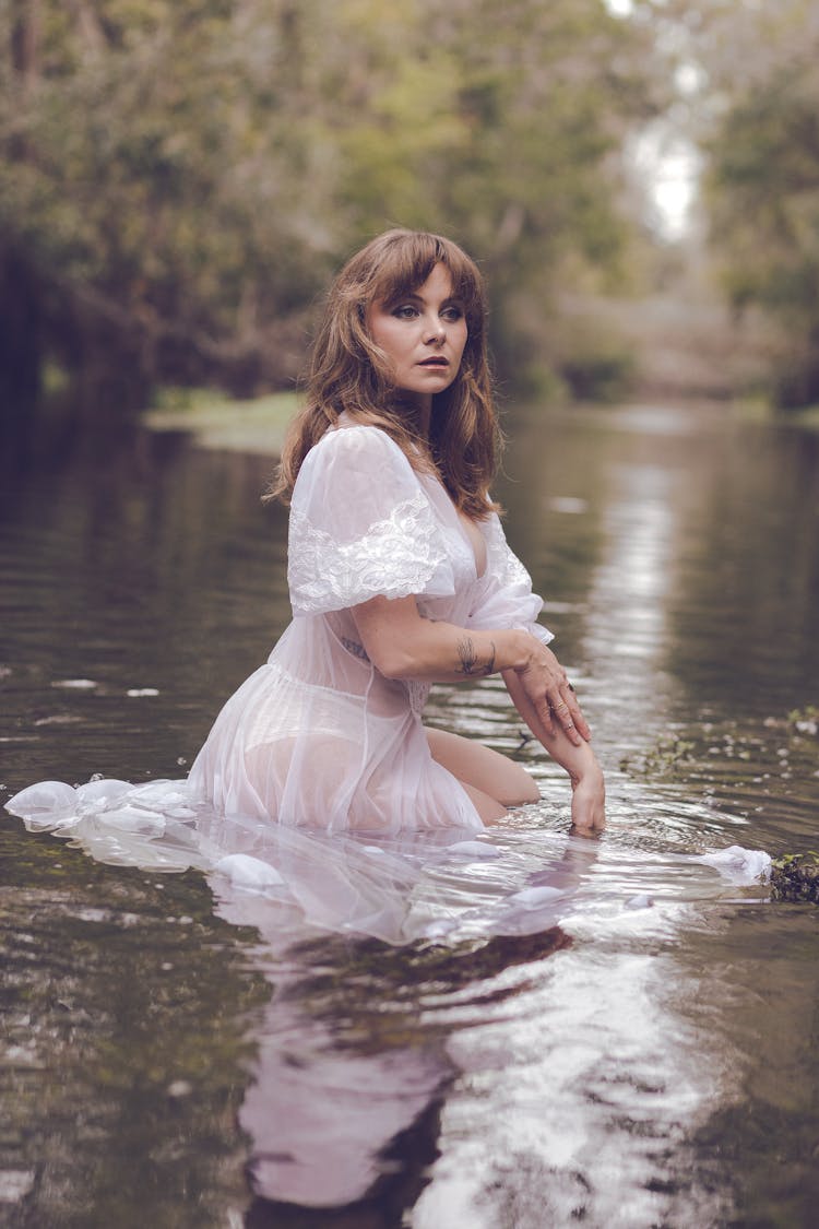 Woman In White Dress In Water In Summer Forest