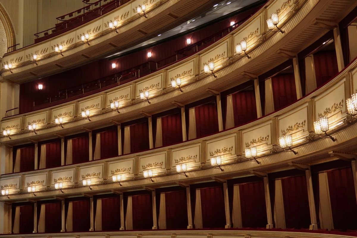 Interno di un teatro lirico con palchi dorati e velluto rosso