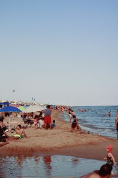 Vibrant summer beach scene in Barcelona, featuring sunbathers and sea activities along the sandy shoreline.