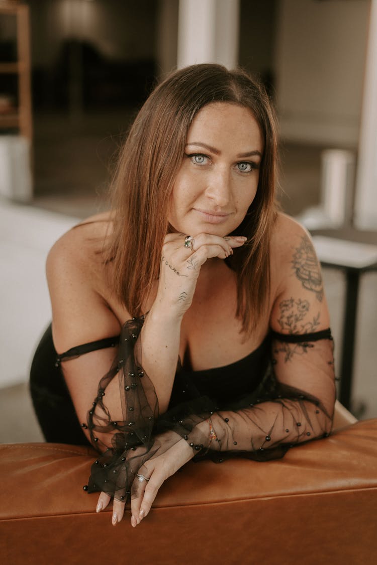 Woman With Tattoos Posing On Leather Couch