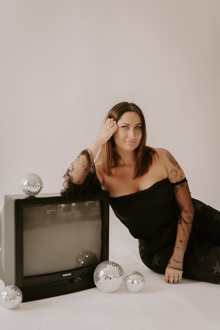 Woman With Tattoos Posing In Studio With TV