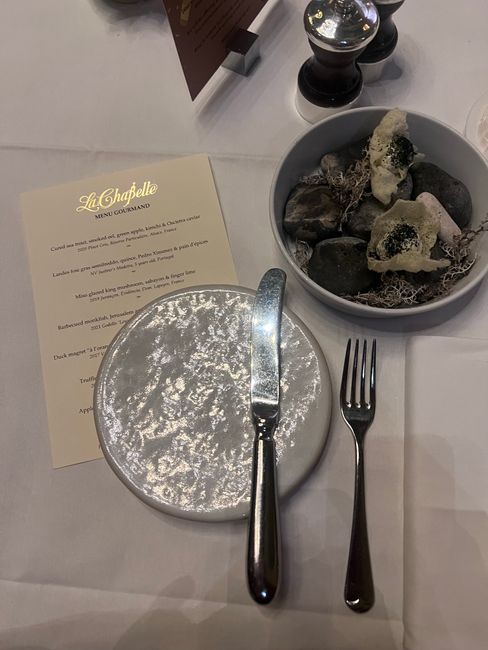Sophisticated table setup with menu and unique dish presentation at a gourmet restaurant.