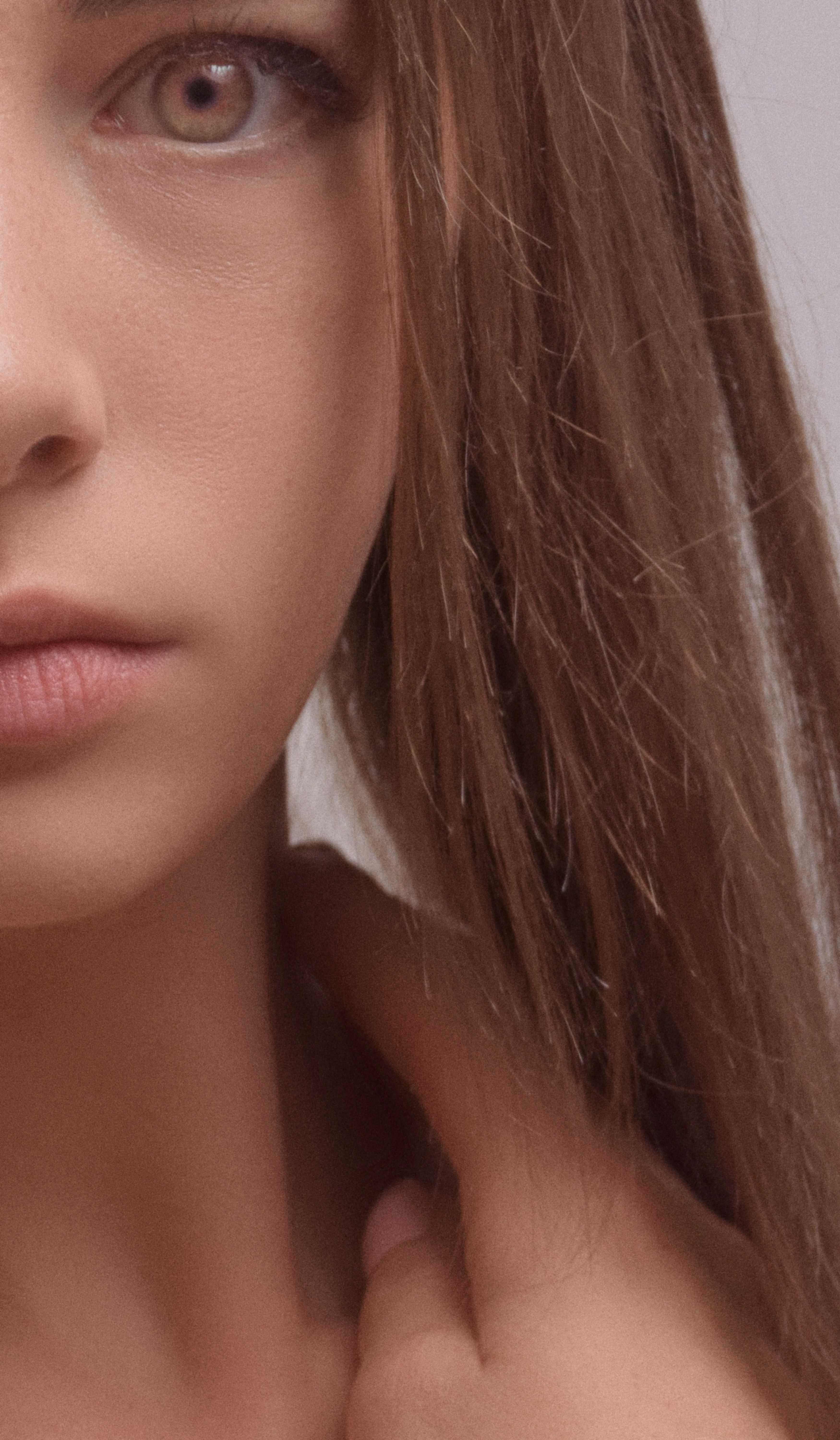 Close-up portrait of a young woman with long brown hair, focusing on facial features.