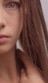 Close-up portrait of a young woman with long brown hair, focusing on facial features.