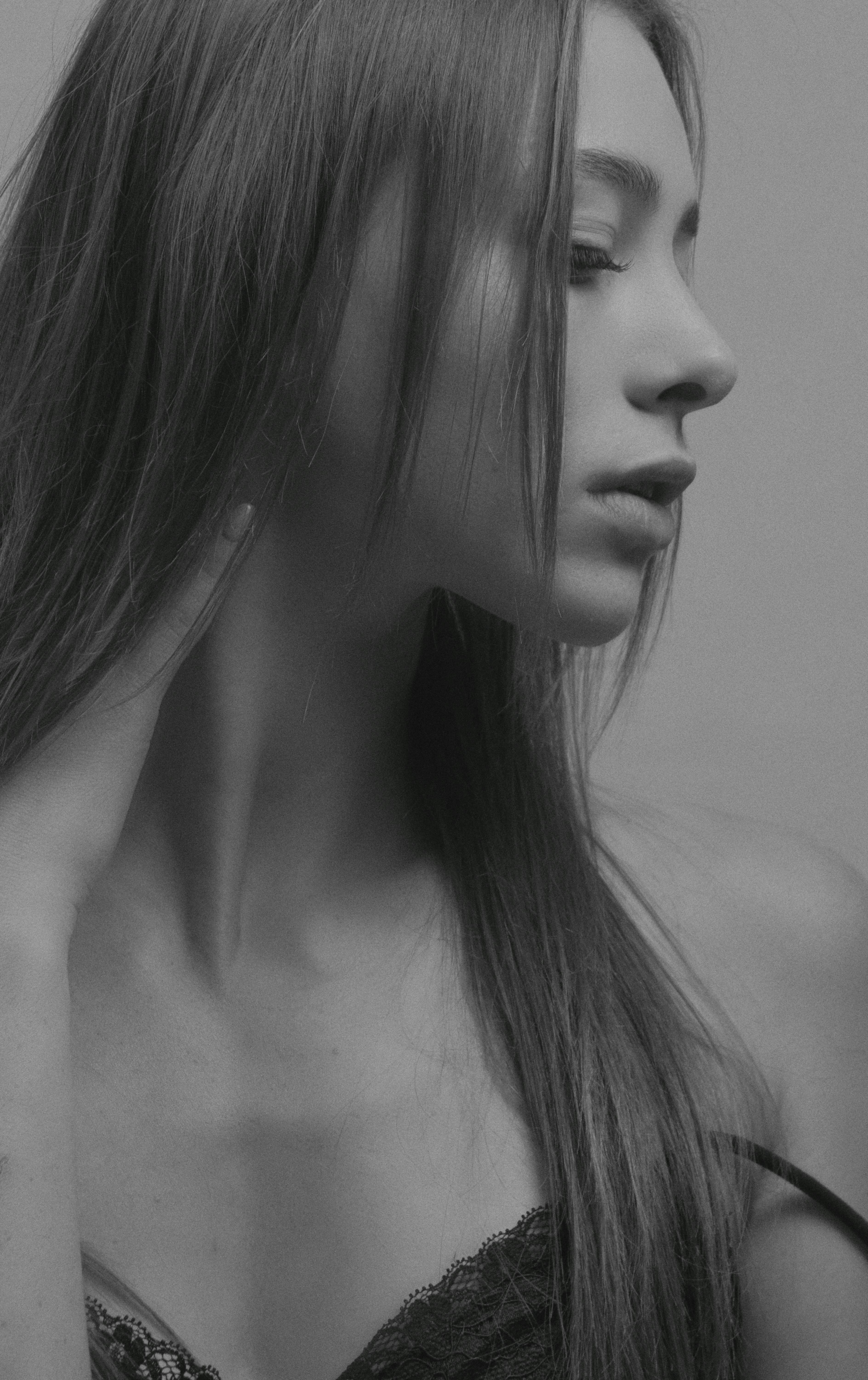 Graceful black and white portrait of a woman looking down, exuding elegance and poise.