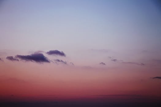 A beautiful sunset with pastel pink and blue hues featuring soft clouds in the sky.