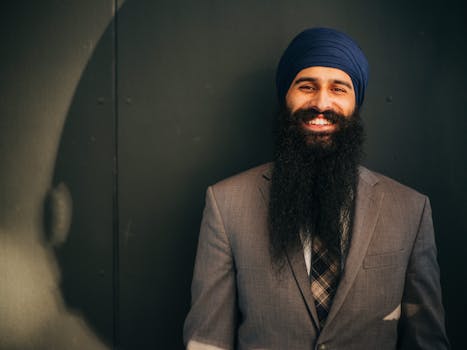 Smiling man in corporate attire with a long beard, exuding confidence.