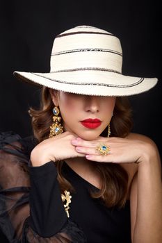 Portrait of a stylish woman in a Panama hat, showcasing elegant jewelry.