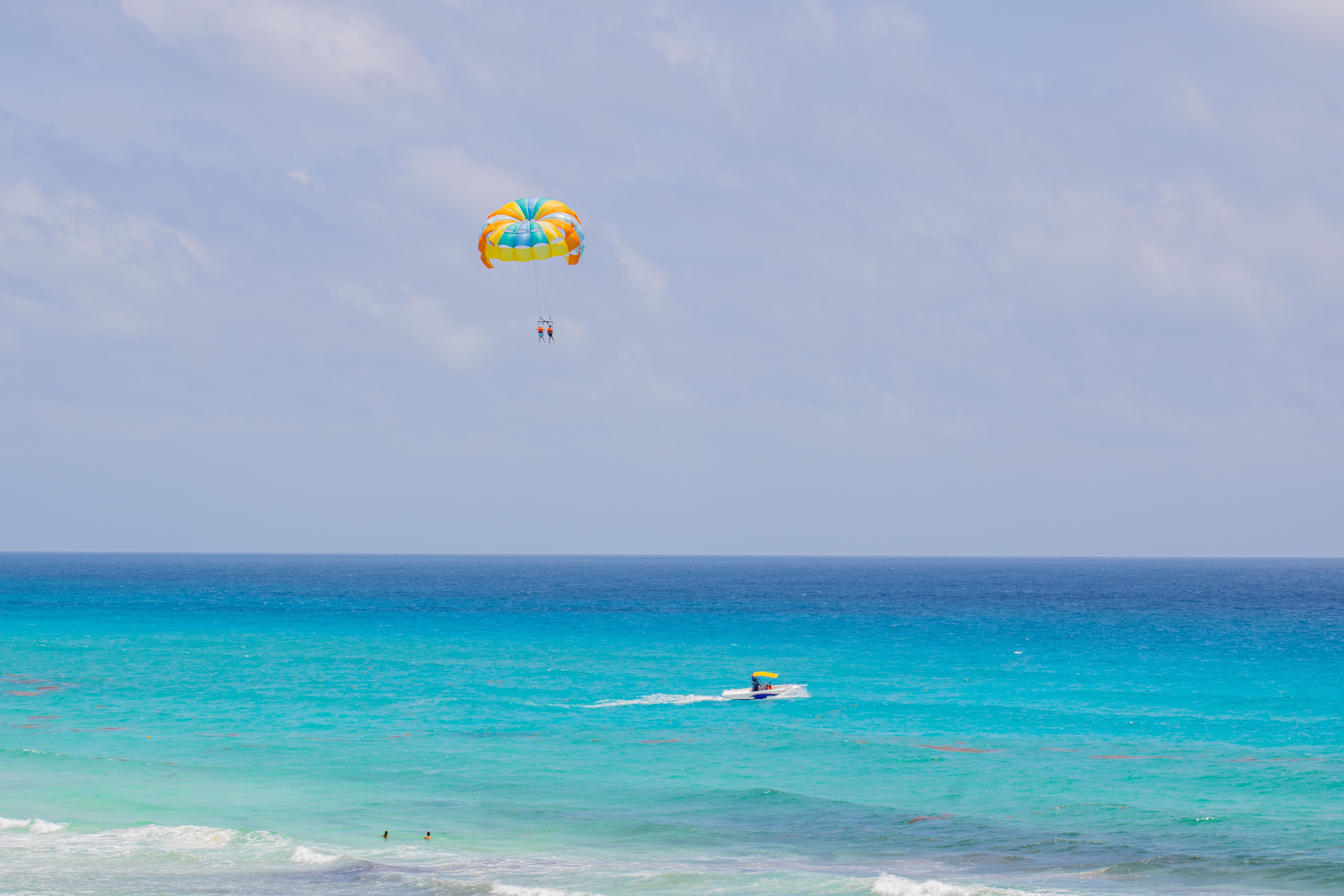 Experience thrilling parasailing above the turquoise sea in Cancún, México. Perfect vacation escape.